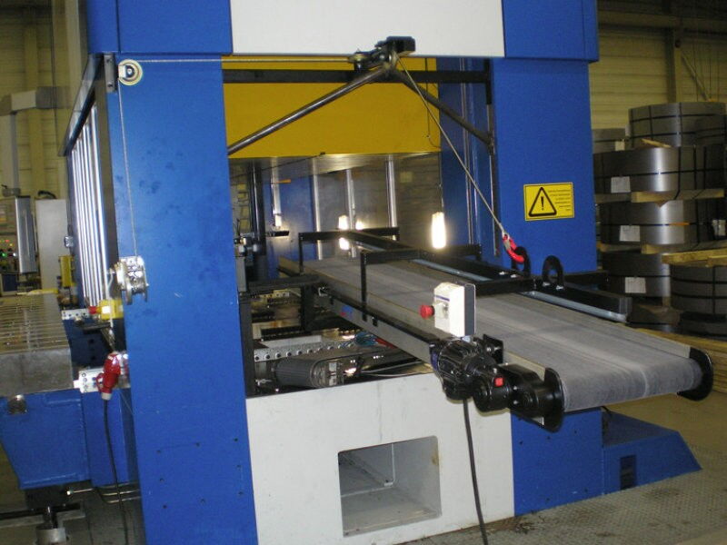 Stable cleatless conveyor belt with ring magnets for a safe conveying of metal parts